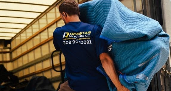 Moving professional carrying a large packed item for home relocation.