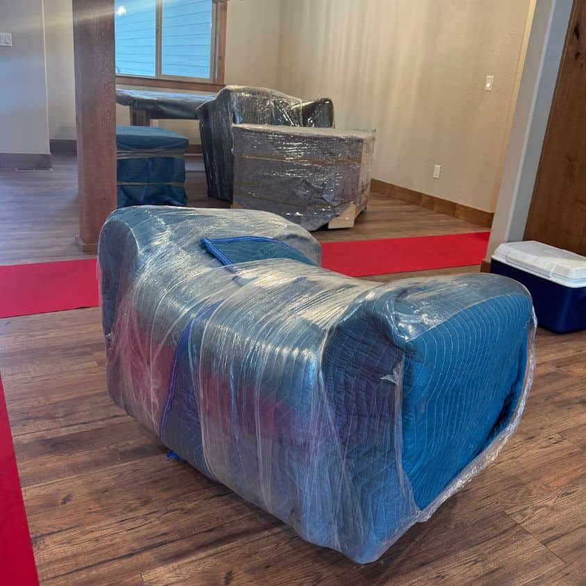 Wrapped furniture ready for moving in a home or office setting.